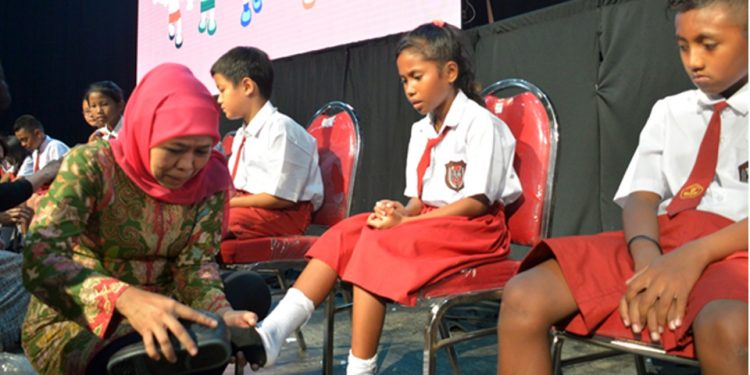 Gubernur Khofifah Pakaikan Sepatu ke Siswa Dengan Lembut